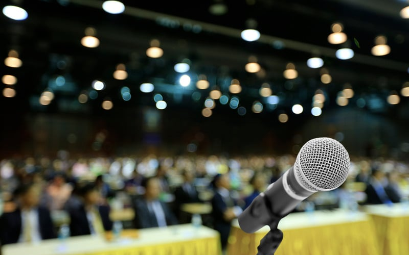 upfront sharp focus on microphone background audience blurred